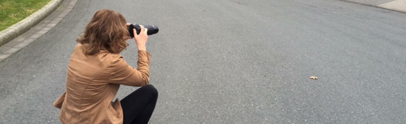 Detektivin bei einer Beobachung mit Kamera